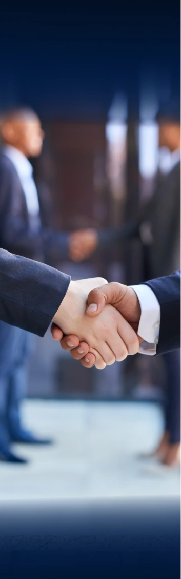 Close-up of two professionals in dark suits shaking hands in a corporate setting