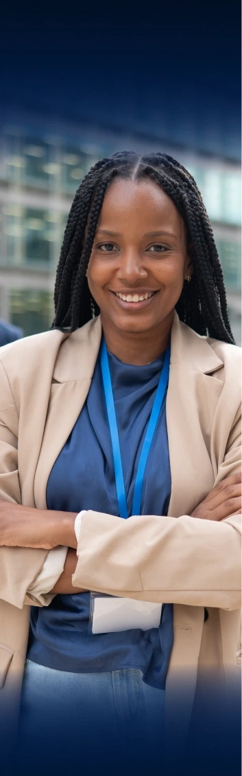 Confident woman with braided hair in a beige blazer standing with arms crossed