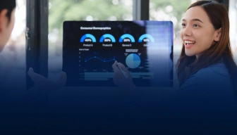 Woman smiling while pointing at a screen showing consumer demographics charts