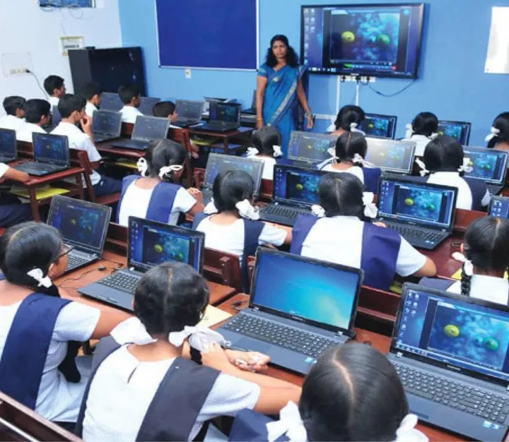 Rows of students working on laptops in a computer lab