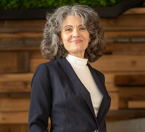 Smiling senior woman with grey curly hair in a navy blazer