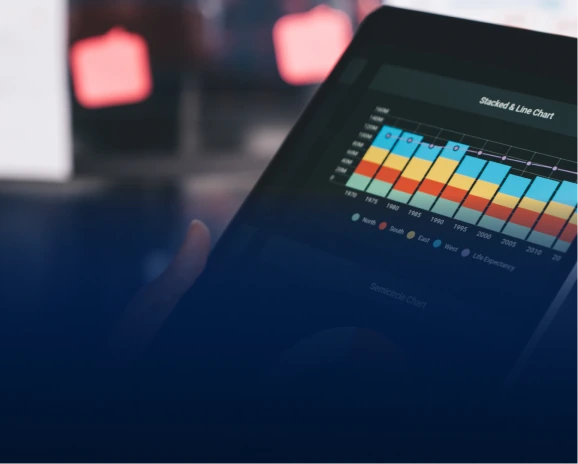 Hand holding a tablet displaying a colourful stacked bar and line chart