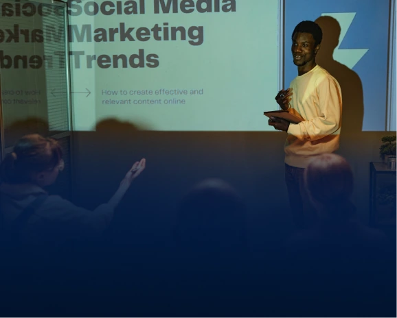 Presenter speaking in front of a social media marketing trends slide to an audience